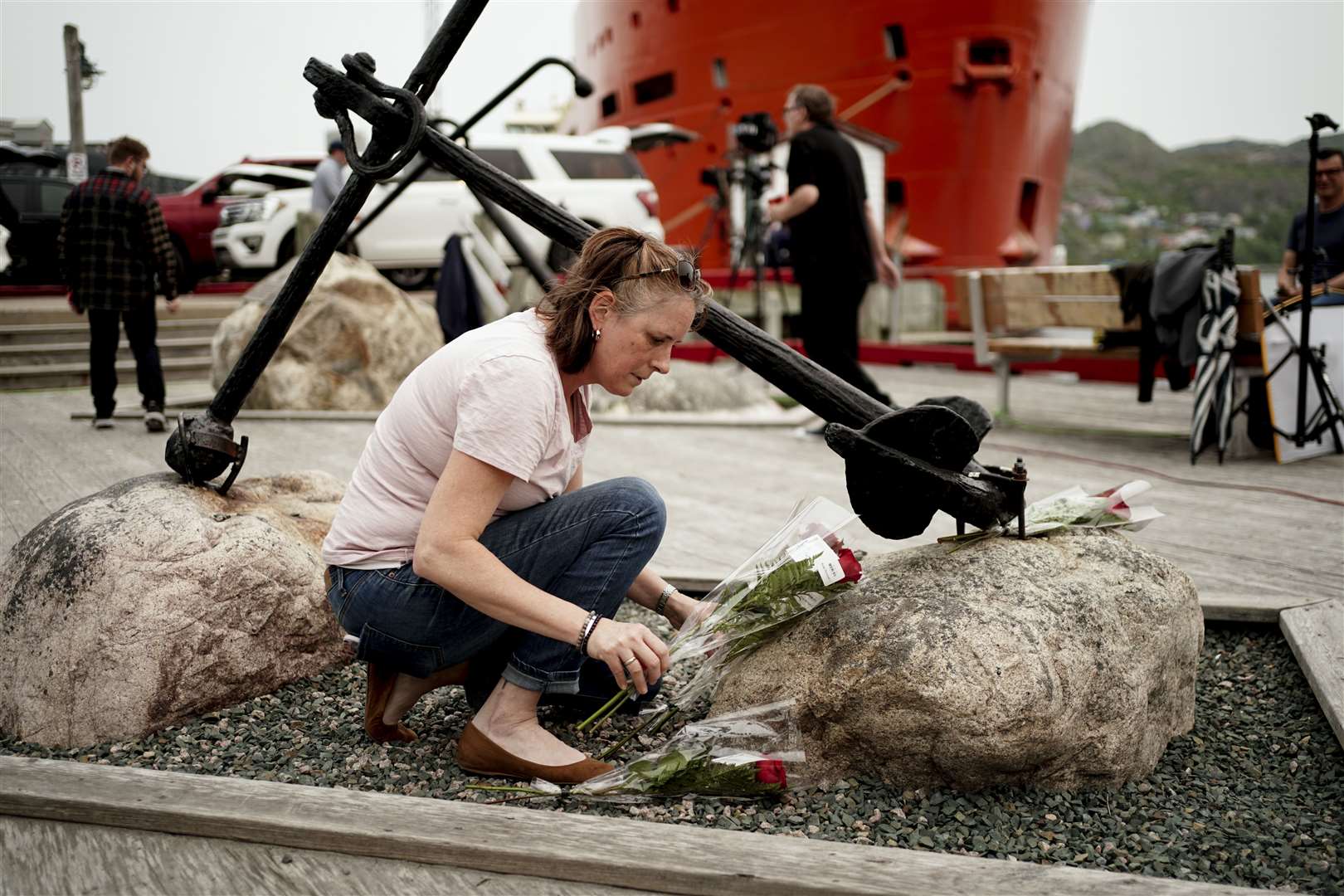 St John’s resident Patsy Power places flowers at an anchor at King’s Beach at the port of St John’s in Newfoundland, Canada (Jordan Pettit/PA)