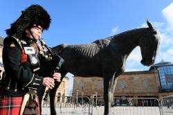 Private Gary Mckay of the Black Watch pipes to signal the arrival of the horse in Falcon Square.