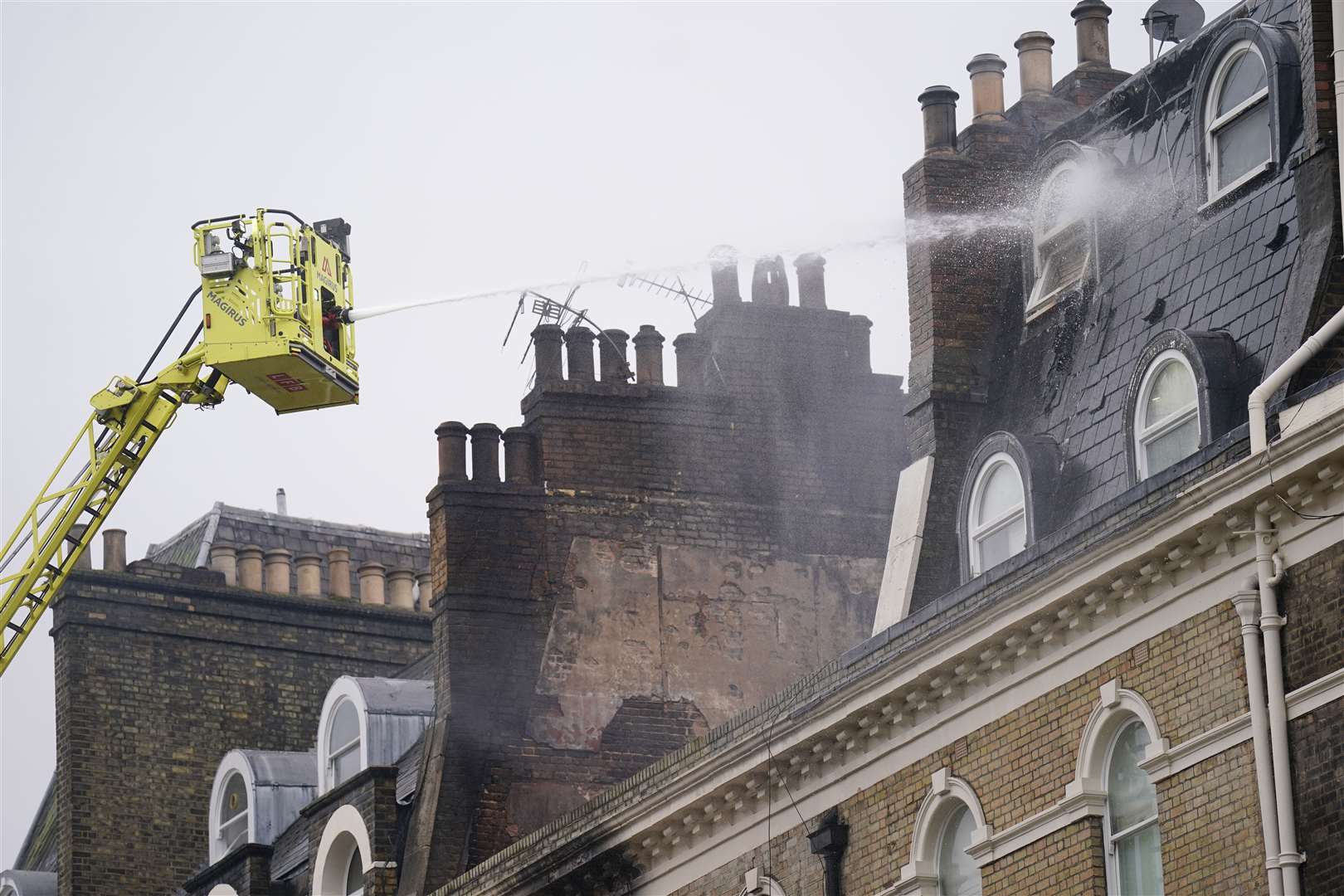 Firefighters deal with the aftermath of the blaze that left 13 people suffering from smoke inhalation (James Manning/PA)
