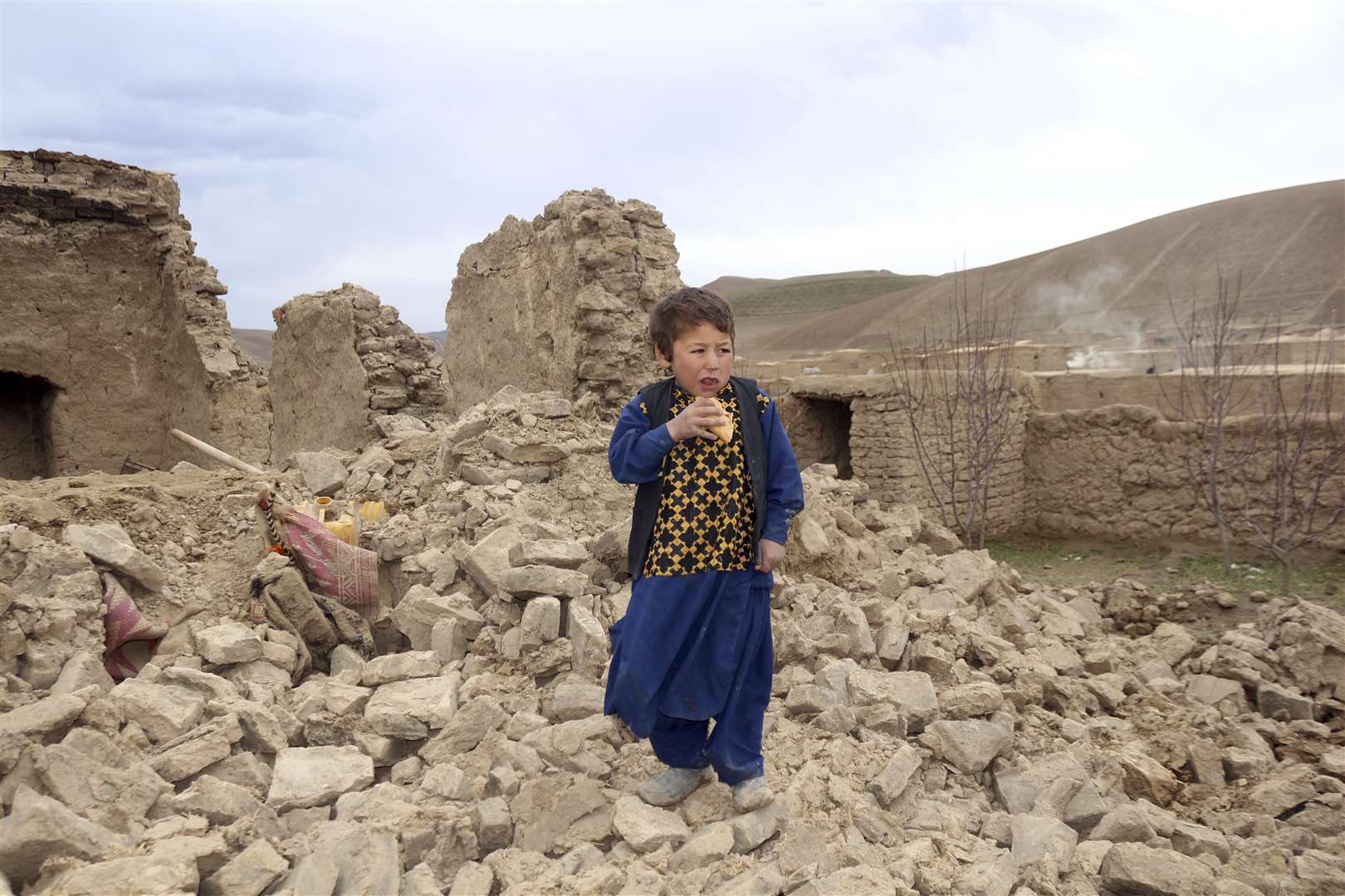 A boy stands near to his damaged house after it was hit by an earthquake in a remote western province of Badghis, Afghanistan last week (Abdul Raziq Saddiqi/AP)