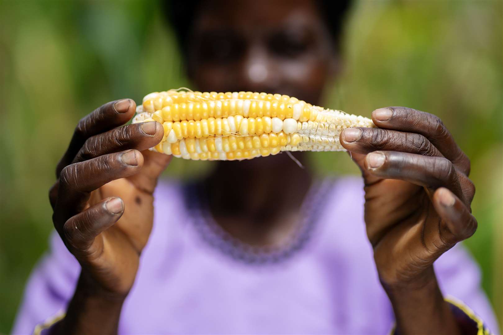 Malita Mussa holds a malformed maize cob outside her home in the village of Manduwasa (Brian Lawless/PA)