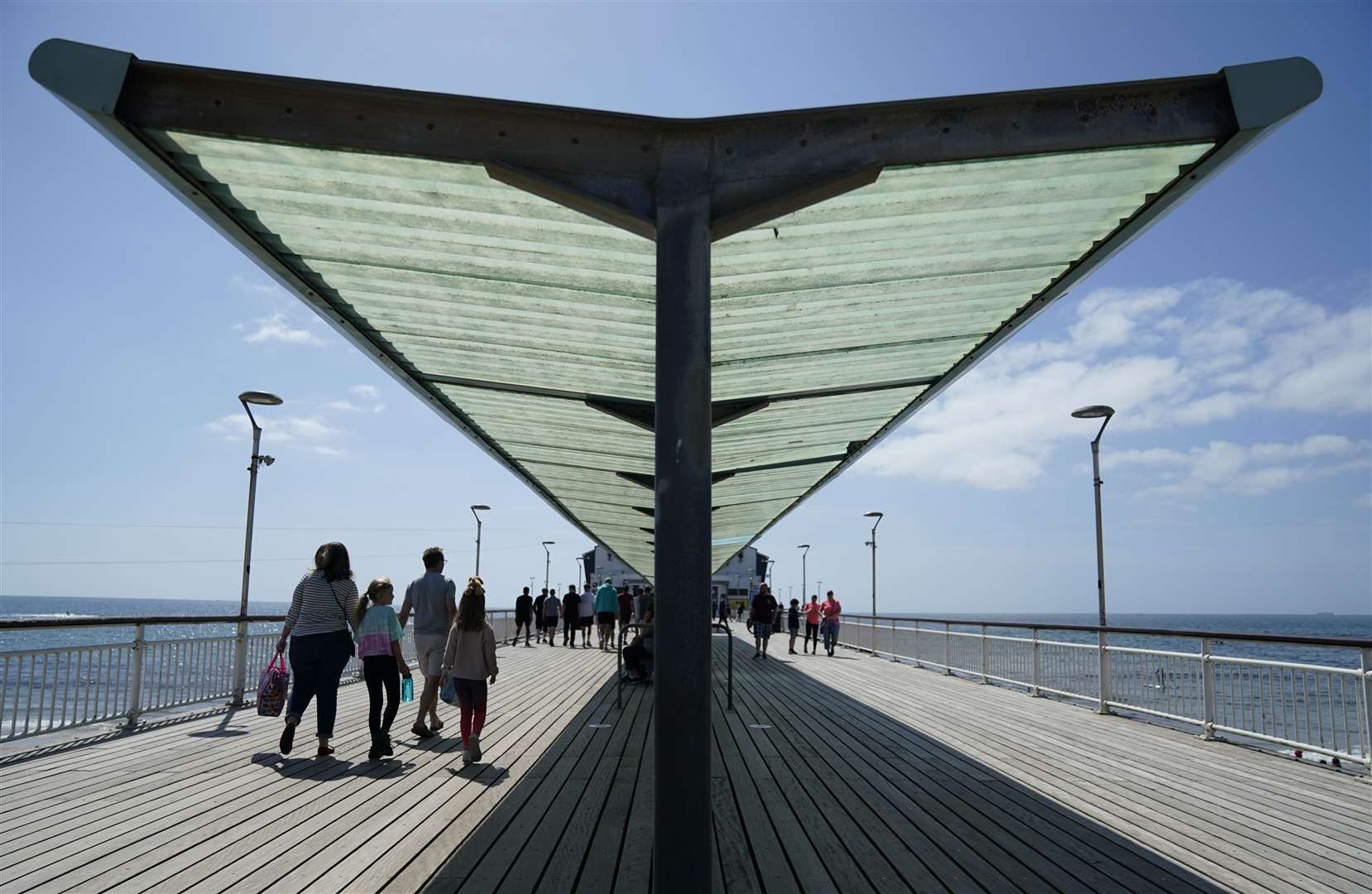 Day-trippers walk along Bournemouth pier to enjoy the views (Andrew Matthews/PA)