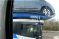 Driver caught using elbow to steer car transporter on motorway