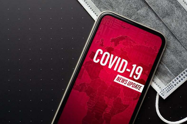 Coronavirus or Covid-19 outbreak News Update background concept. Mockup mobile phone Coronavirus News with facial masks. Flat lay top view with copy space..