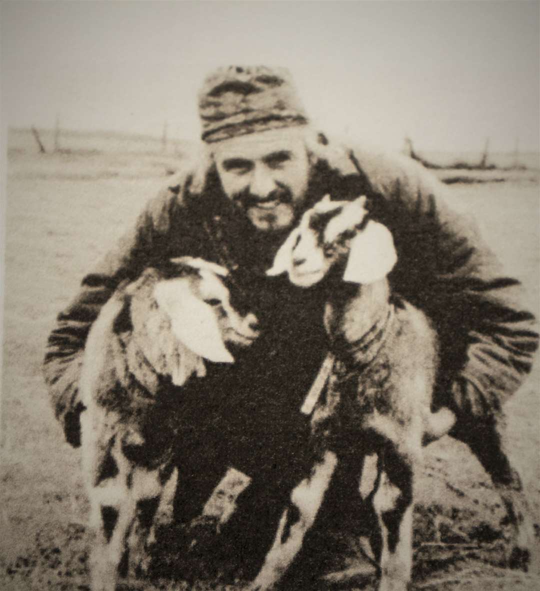 A picture in the book showing Marcus with two of his goat friends.