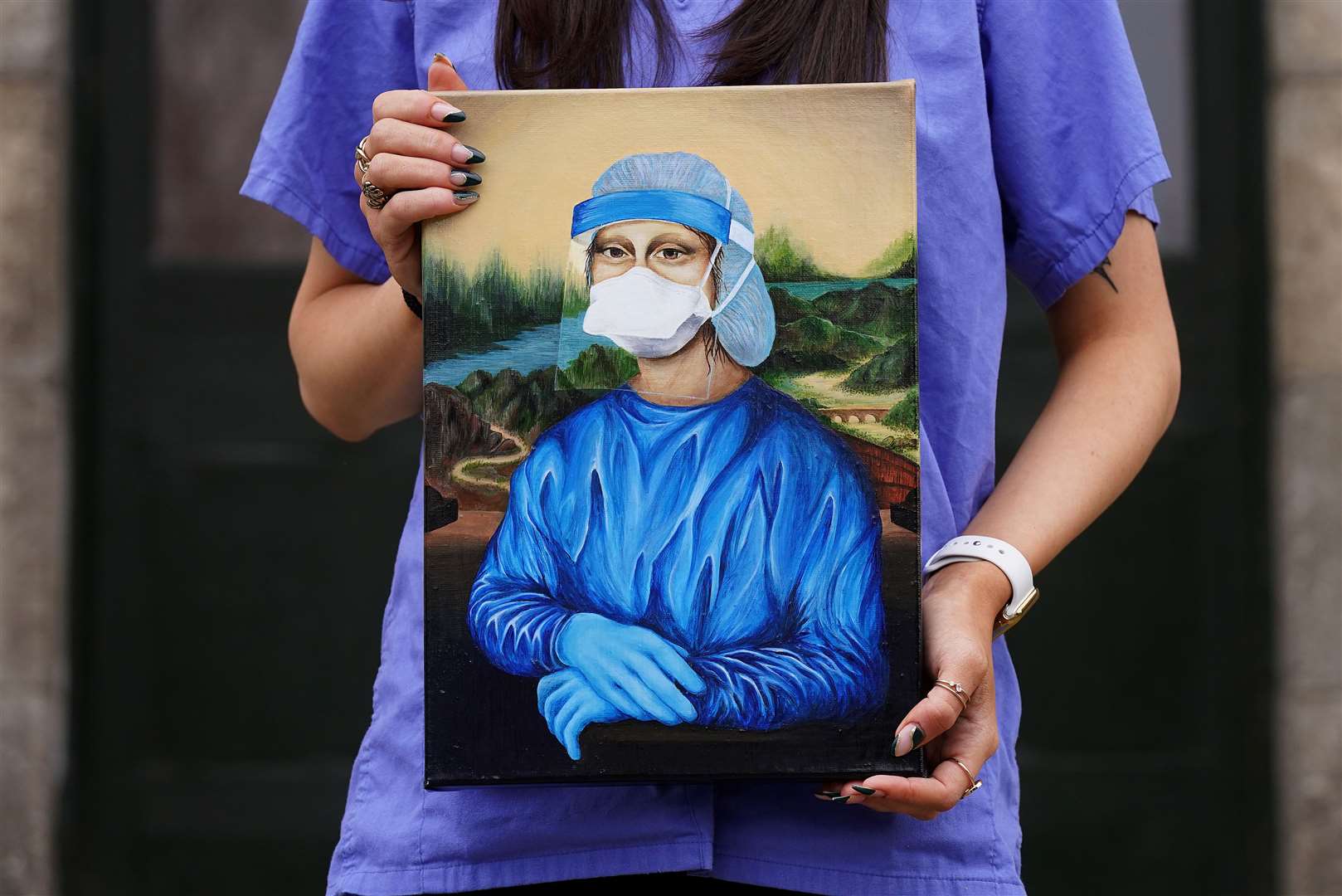Trainee nurse Chloe Slevin holds her painting Corona Lisa (Brian Lawless/PA)
