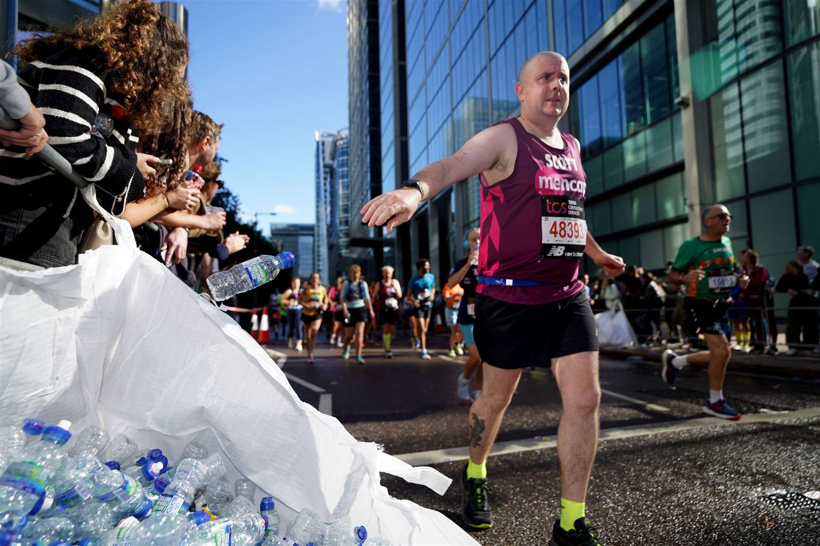 Runners who grab a bottle of water on the TCS London Marathon route are encouraged to ‘Drink, Drain, Drop’ so the empty bottle can be collected for recycling (James Manning/PA)