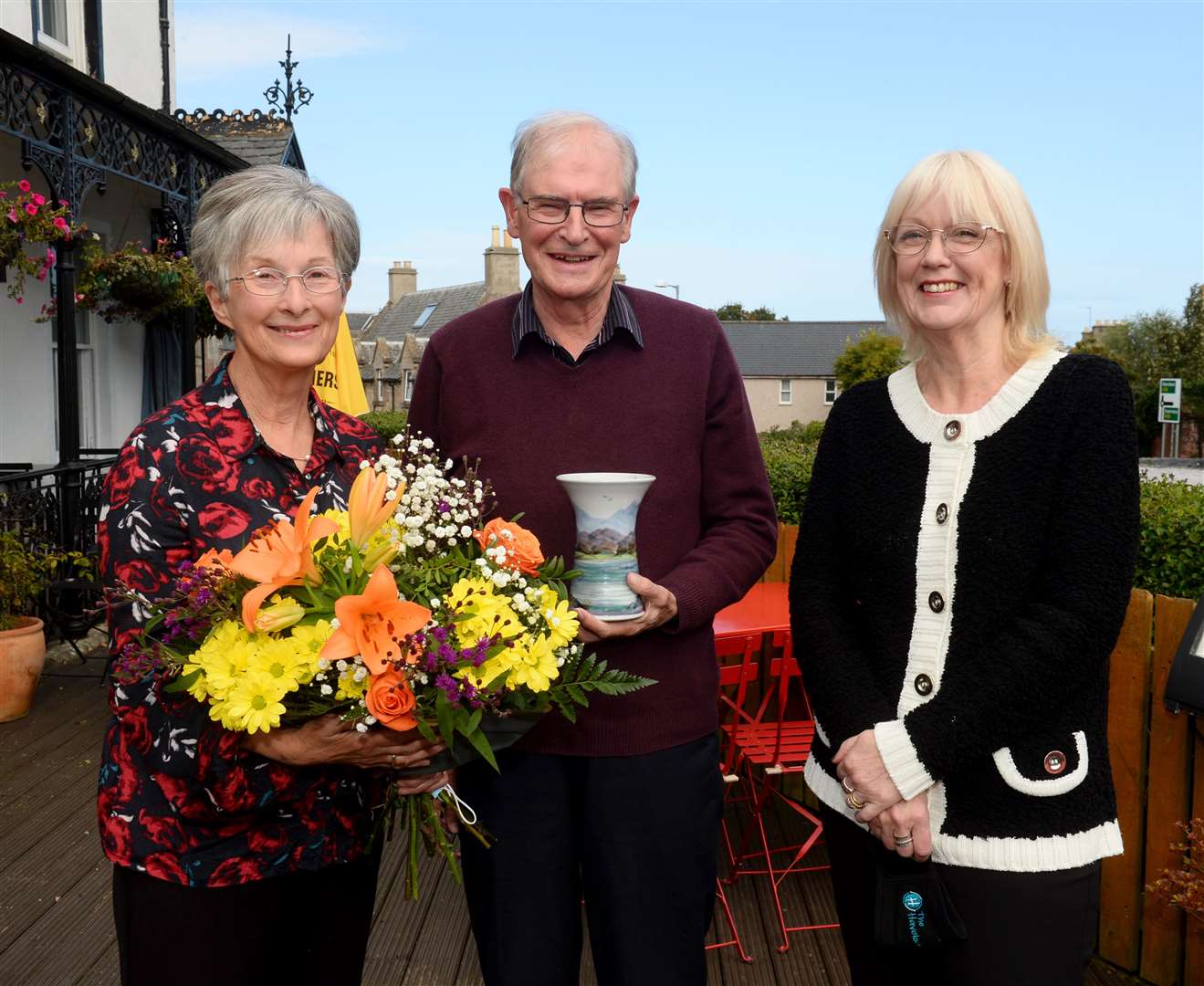 Iain and Jane Fairweather are presented flowers and Scottish stoneware by VisitNairn vice-chairman Morag Holding.