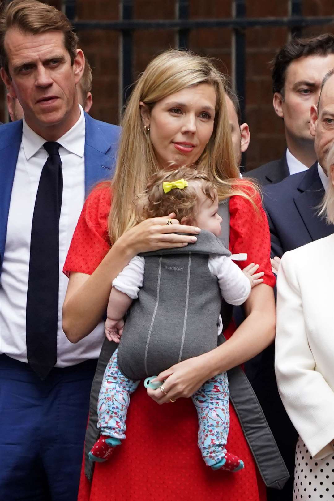 Mrs Johnson cradles daughter Romy as she listens to her husband resigns as Conservative Party leader in 2022 (PA)