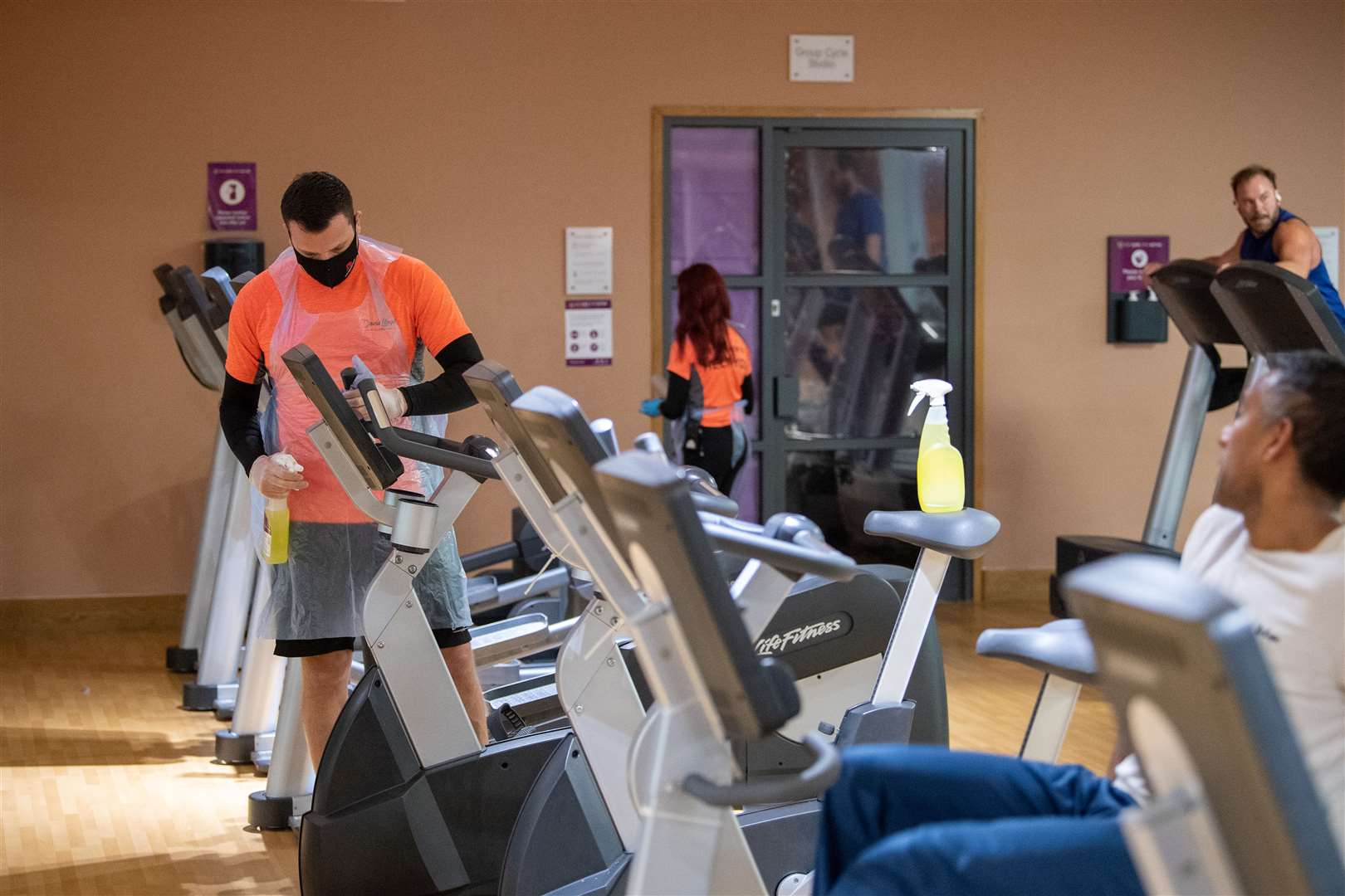 Members of staff clean gym equipment at David Lloyd health club in Leicester as they reopen after England’s second national lockdown ended (Joe Giddens/PA)