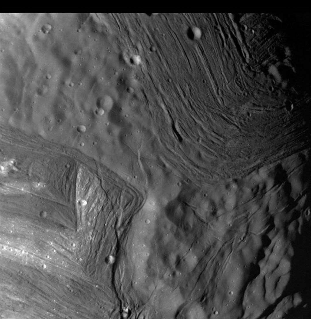 Fault scarps around Elsinore Corona (pictured in the top right) and the chevrons of Inverness Corona (seen in the bottom left of the shot) in this image from the Voyager II space probe.