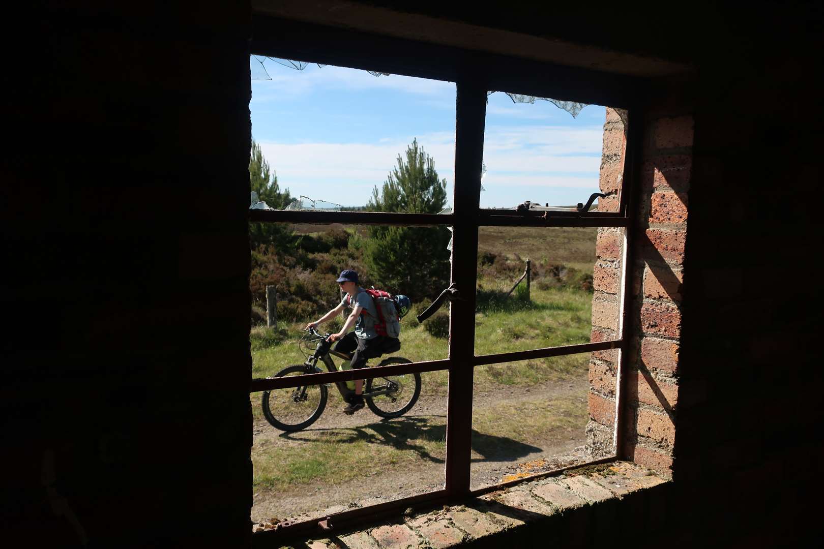Eoghain passing the window of an old building beside the former railway line.