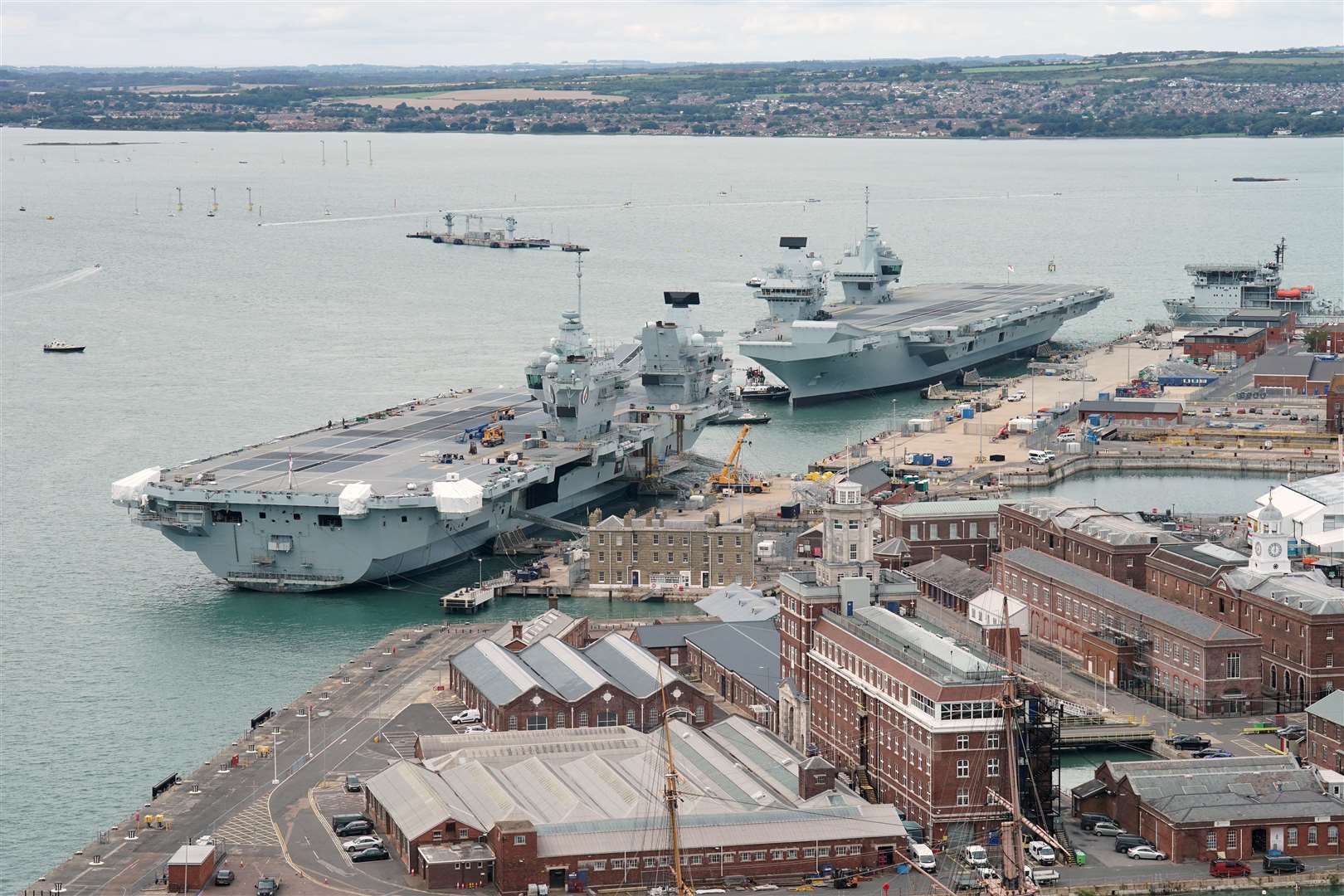 HMS Prince of Wales (top right) berths alongside aircraft carrier HMS Queen Elizabeth as it arrives at Portsmouth naval base (Jonathan Brady/PA)
