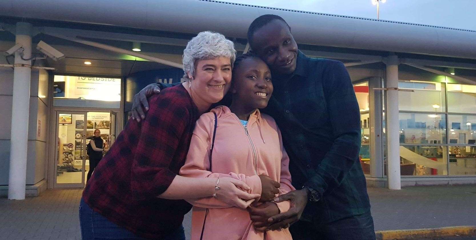 Denis and Shelagh Omondi are reunited with Denis's daughter Ann at Inverness Airport.