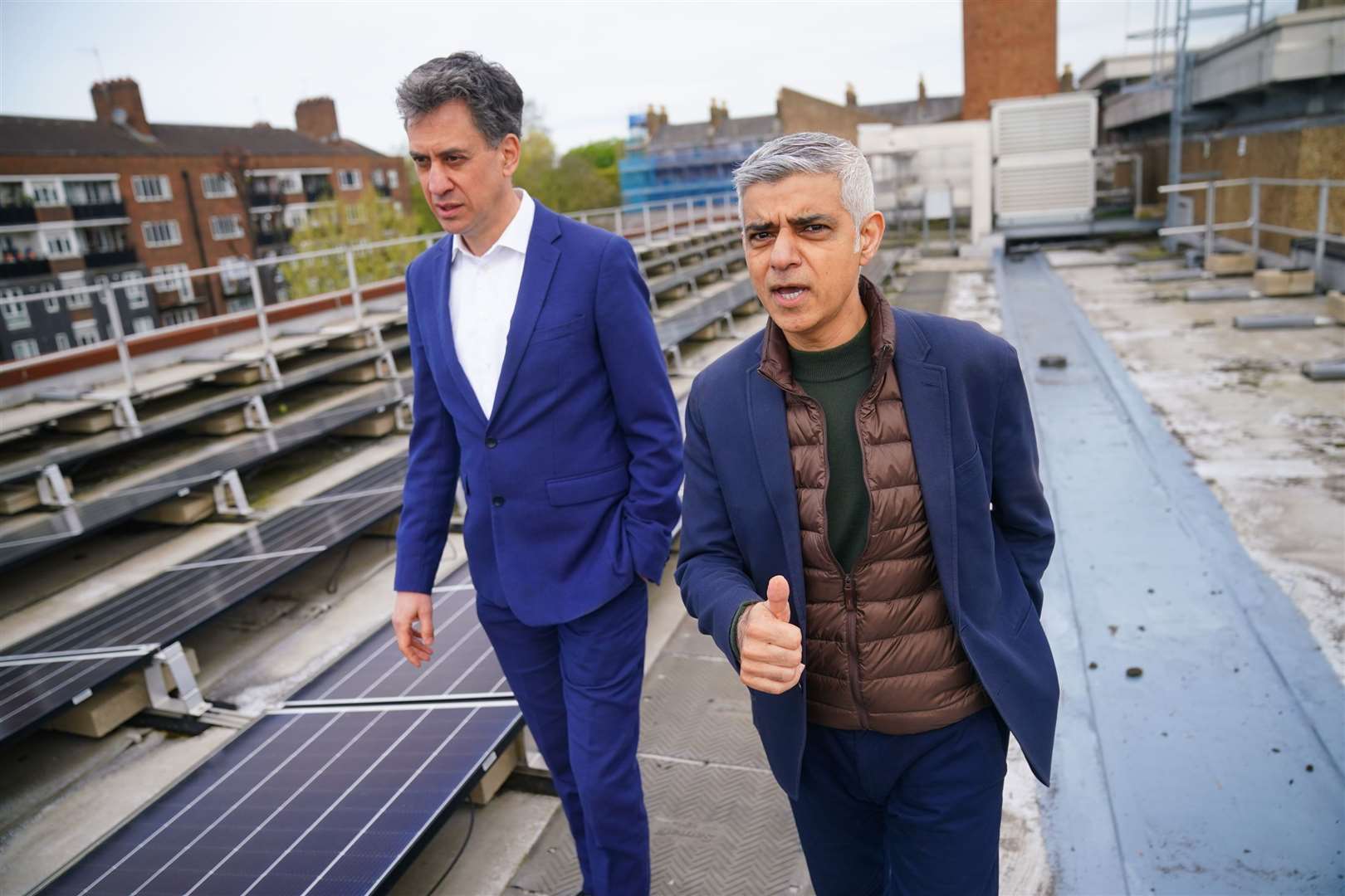 Mayor of London Sadiq Khan and shadow energy secretary Ed Miliband, walk past solar panels installed on the roof of Stoke Newington School in north London (Victoria Jones/PA)