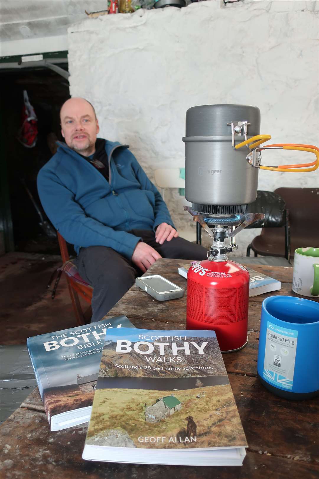 Geoff Allan in his natural habitat inside Ryvoan bothy - along with his two books on bothies.