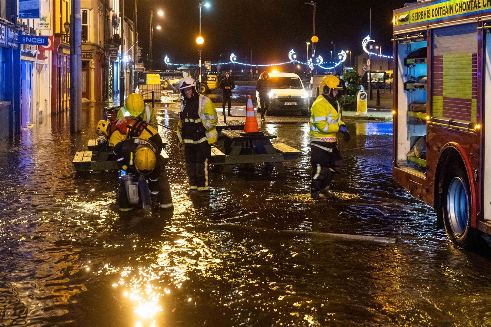 Firefighters pump floodwaters in Bantry, County Cork, after Storm Barra hit the UK and Ireland with disruptive winds, heavy rain and snow.  (Andy Gibson / AP)