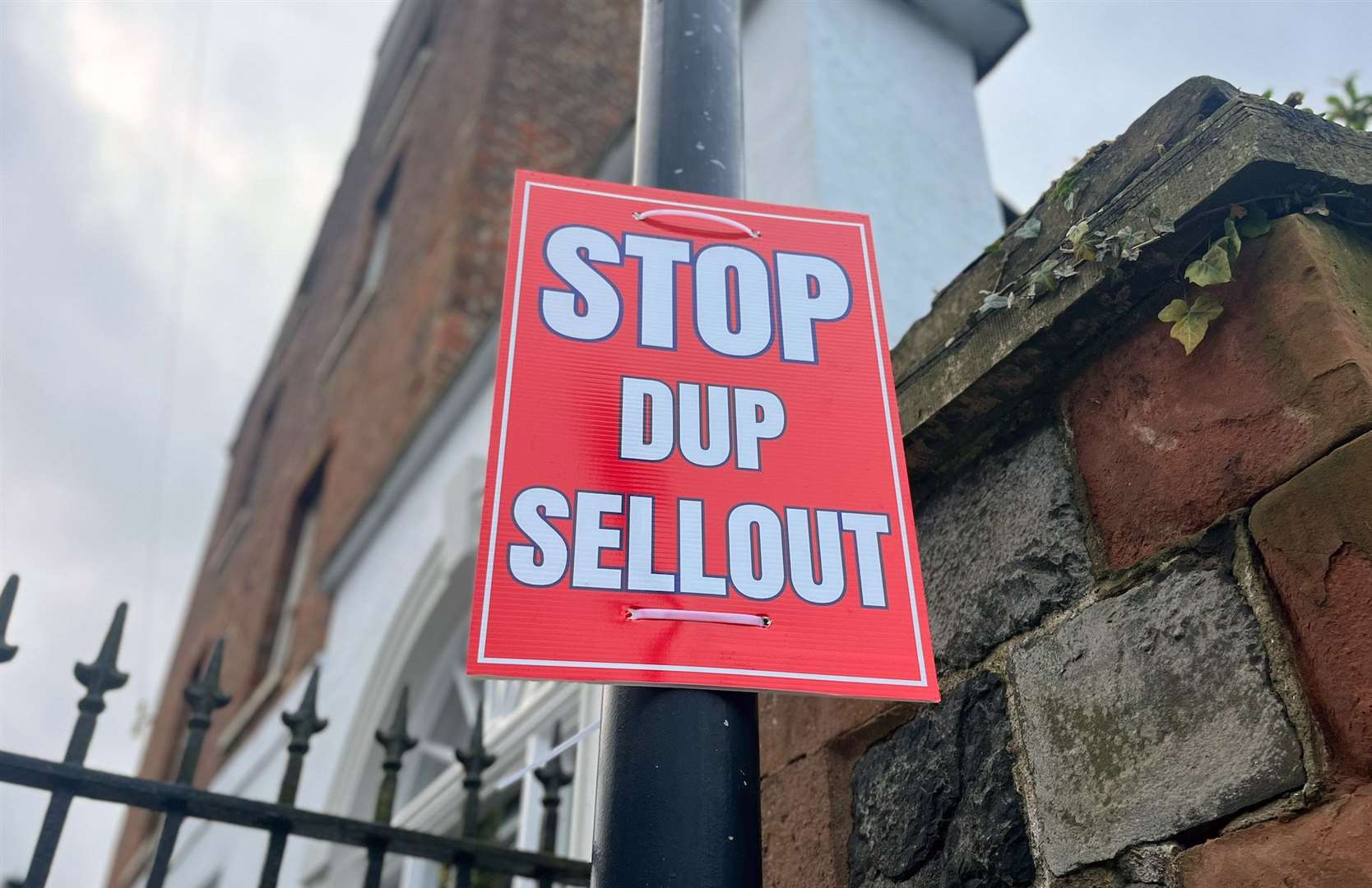 A poster stating “Stop DUP sellout” on a lamppost near Hillsborough Castle (Claudia Savage/PA)