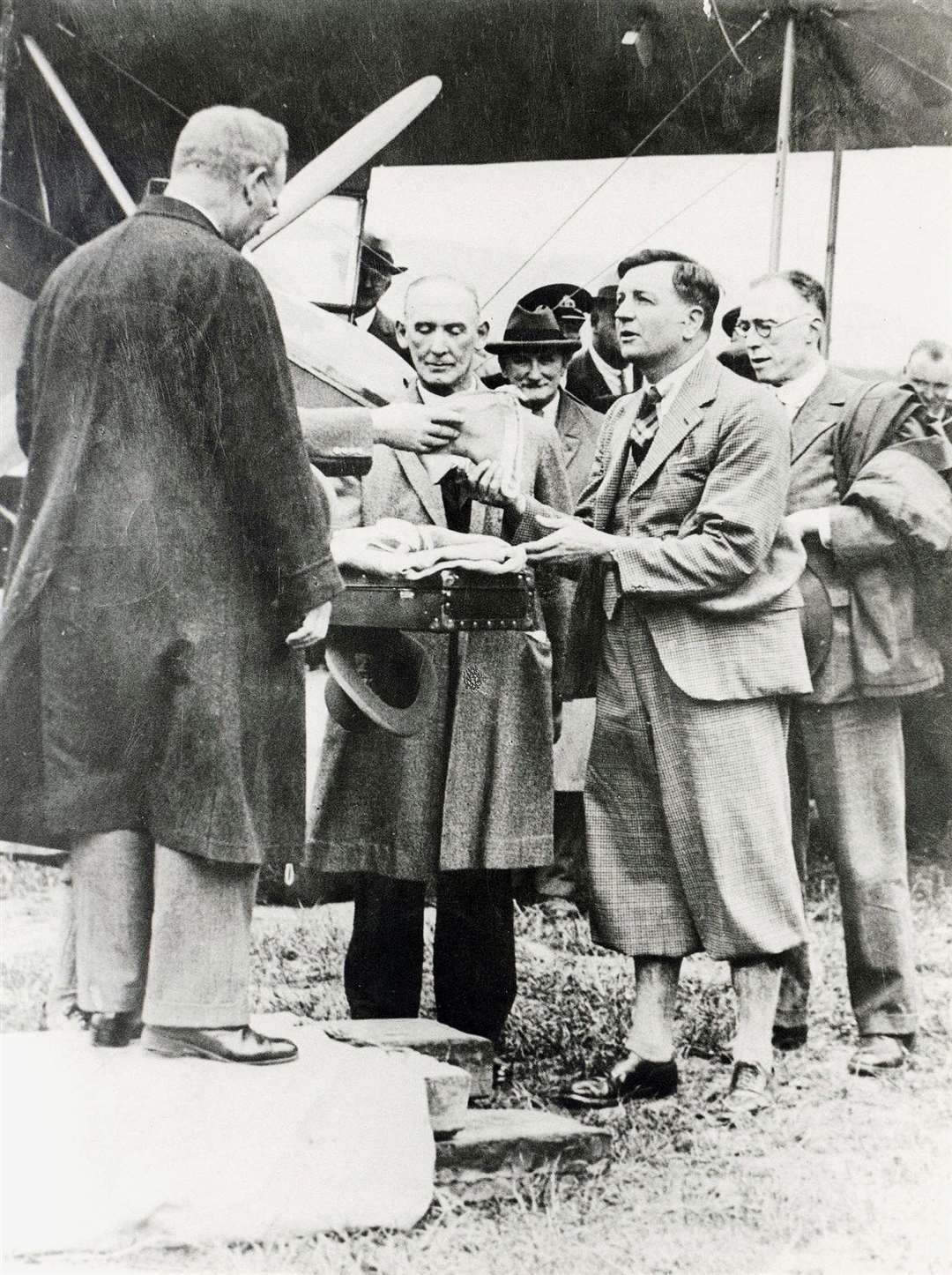 Captain Fresson accepts a special pennant from Sir Frederick Wilson, Britain’s Postmaster General, before the first scheduled air mail flight from Inverness to Orkney in May, 1934. I In centre is AJ Campbell, head postmaster, Inverness. Picture courtesy of Am Baile.