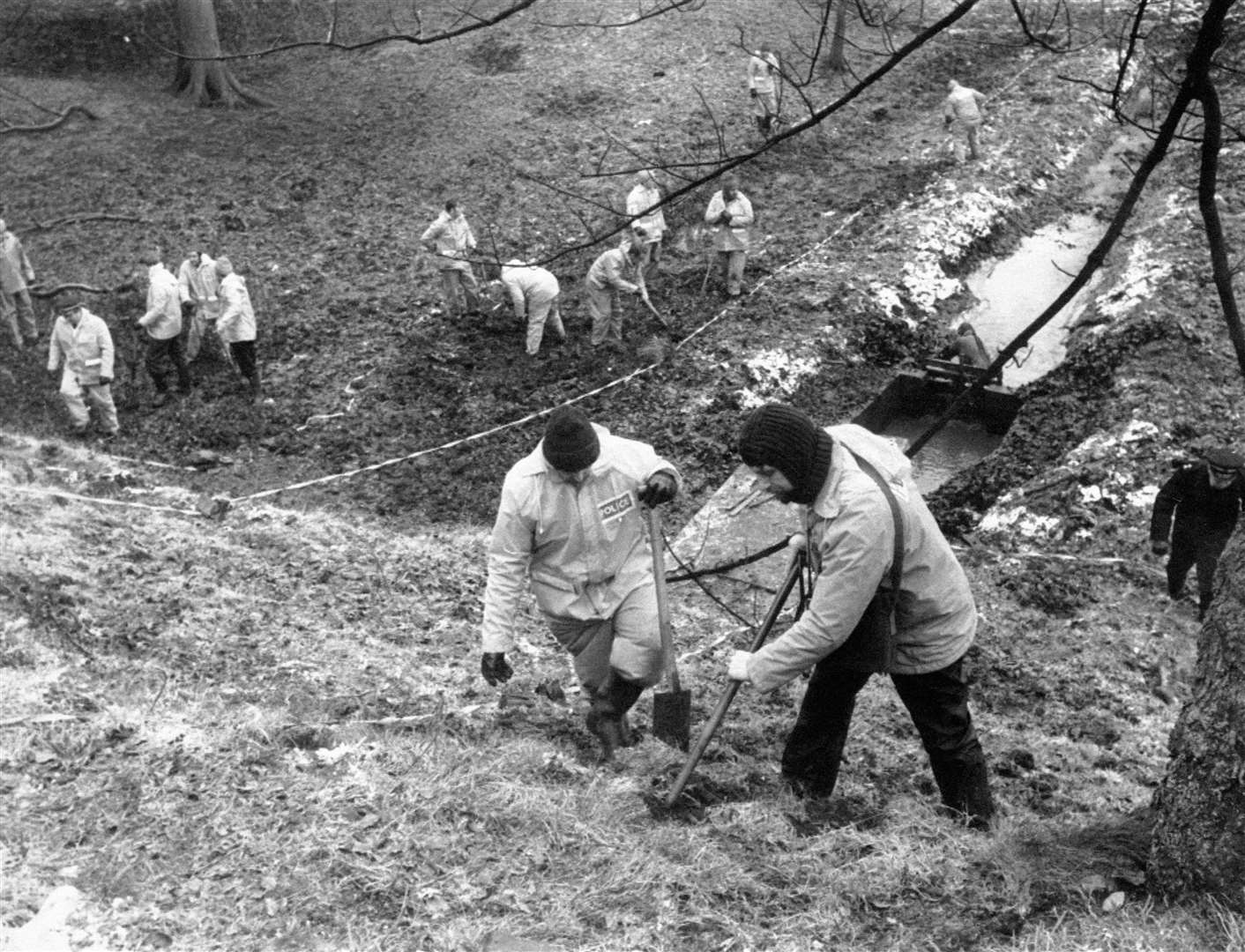 Police using metal detectors to search a field in Bingley, near to the home of Peter Sutcliffe, in 1981 (PA)