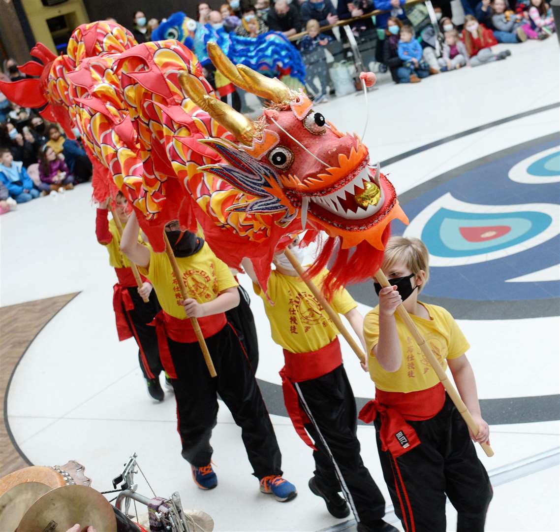 Youngsters parade a dragon.