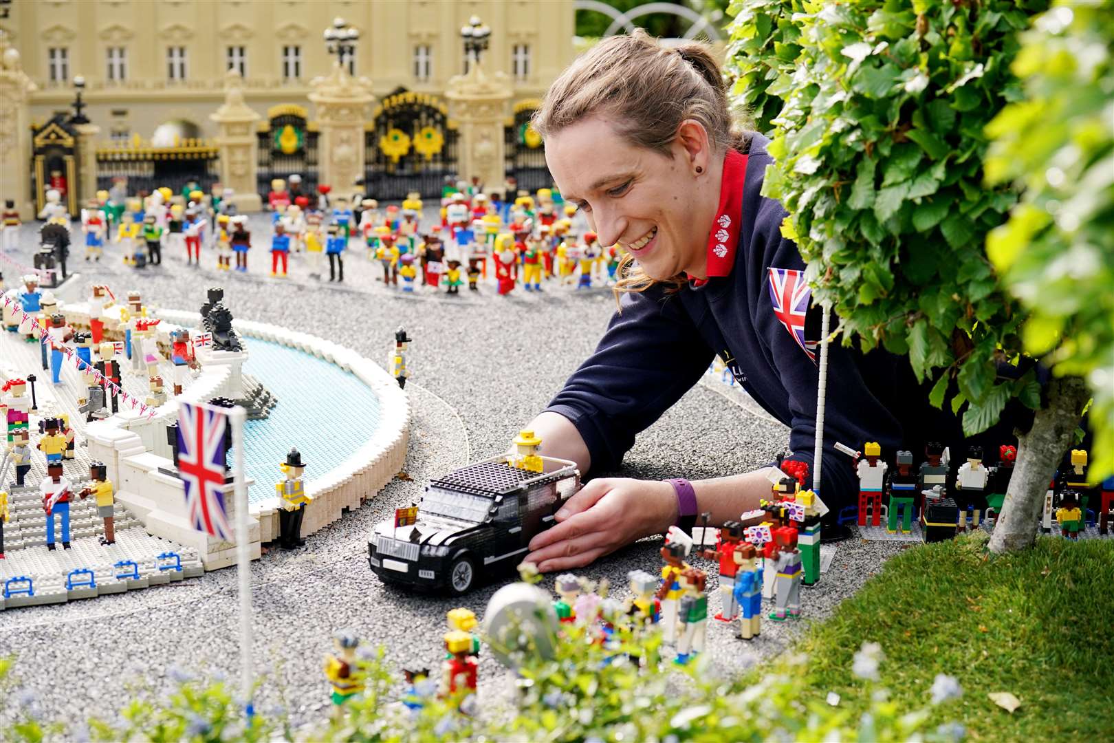 Model Maker Freya Groom places a replica of the Queen, re-imagined in Lego Bricks (Jonathan Brady/PA)