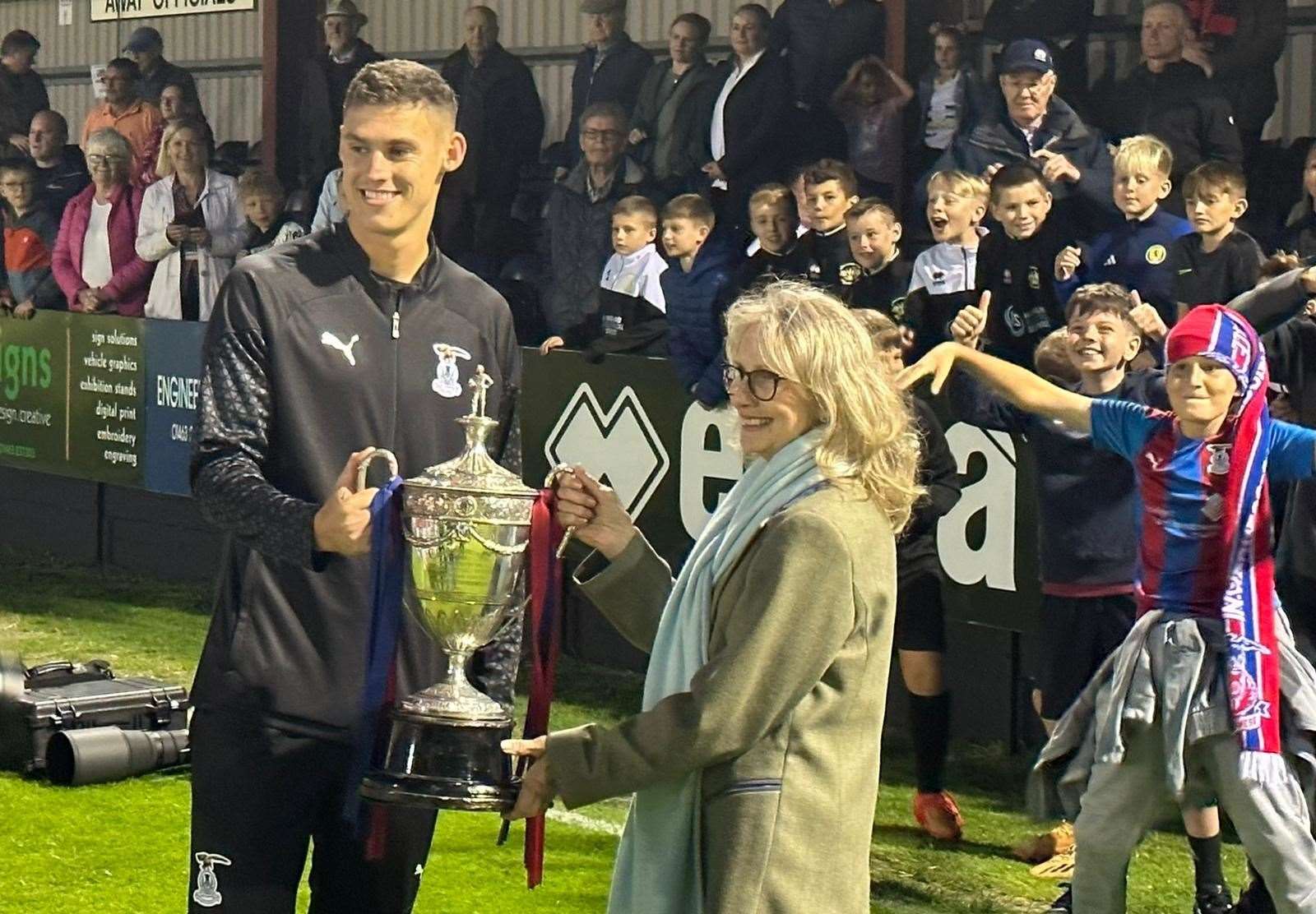 Wallace Duffy, captain for the night, receives the trophy from the city provost