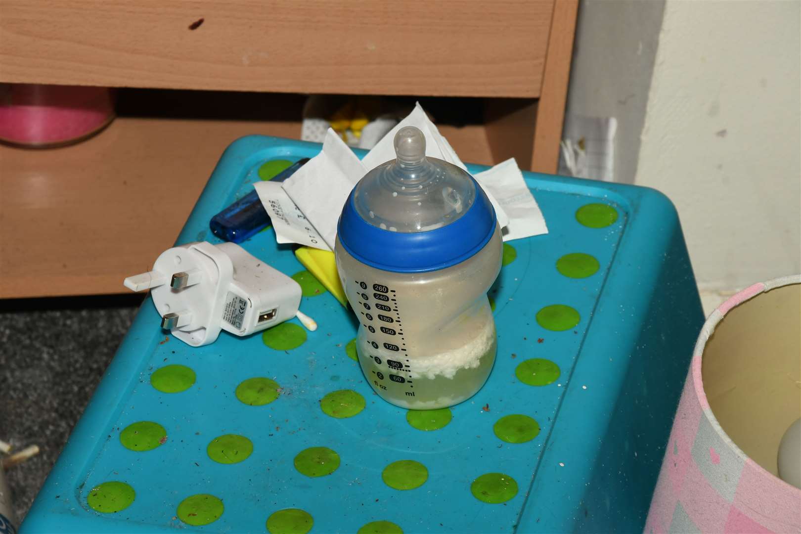 A bottle of gone-off baby’s milk, in the bedroom where Finley slept in a stained cot next to his parents’ bed (Derbyshire Police/PA)