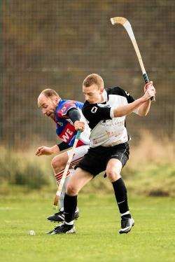 Kingussie's Barrie Dallas tries to block the swing from Lovat's Kevin Bartlett
