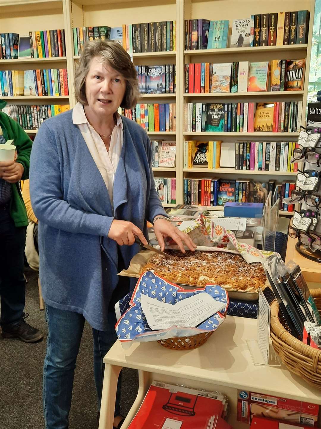 Tina Thomson cutting the birthday cake made by bookseller Izabela.