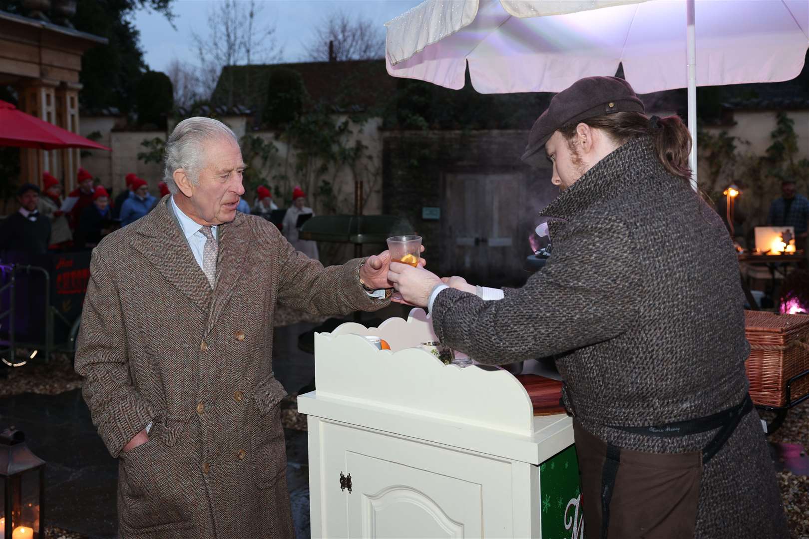 The King is handed a glass of mulled cider (Adrian Dennis/PA)