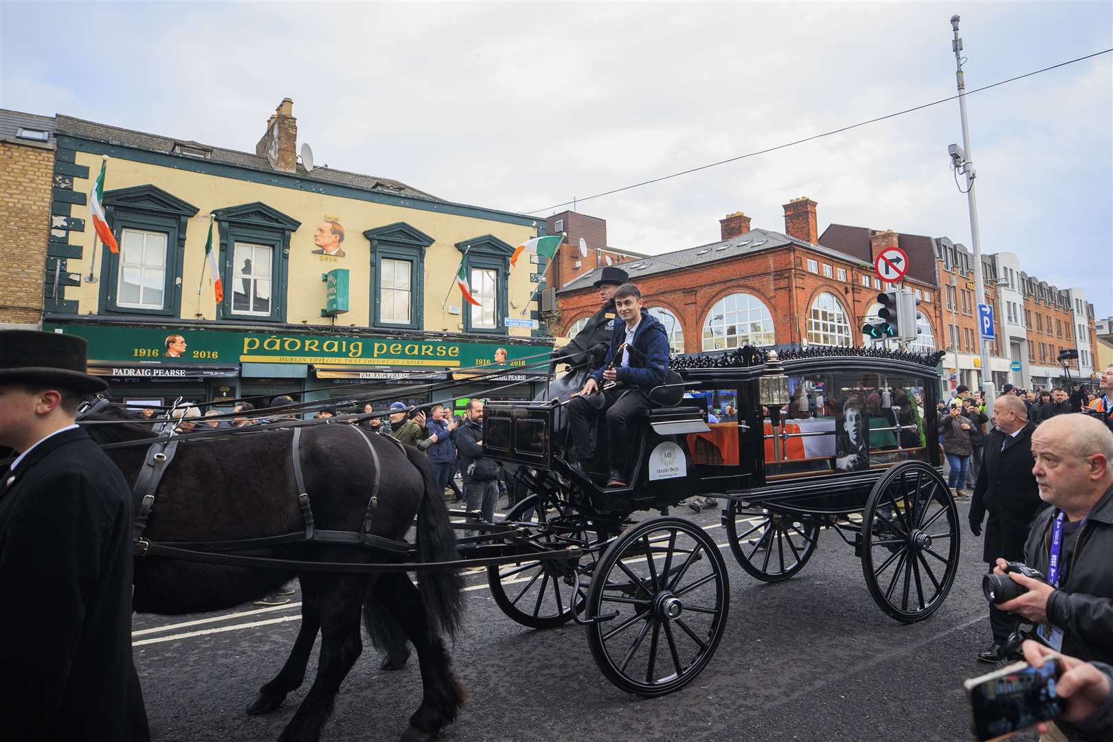 The funeral procession of Shane MacGowan passes the Padraig Pearse Pub (Liam McBurney/PA)