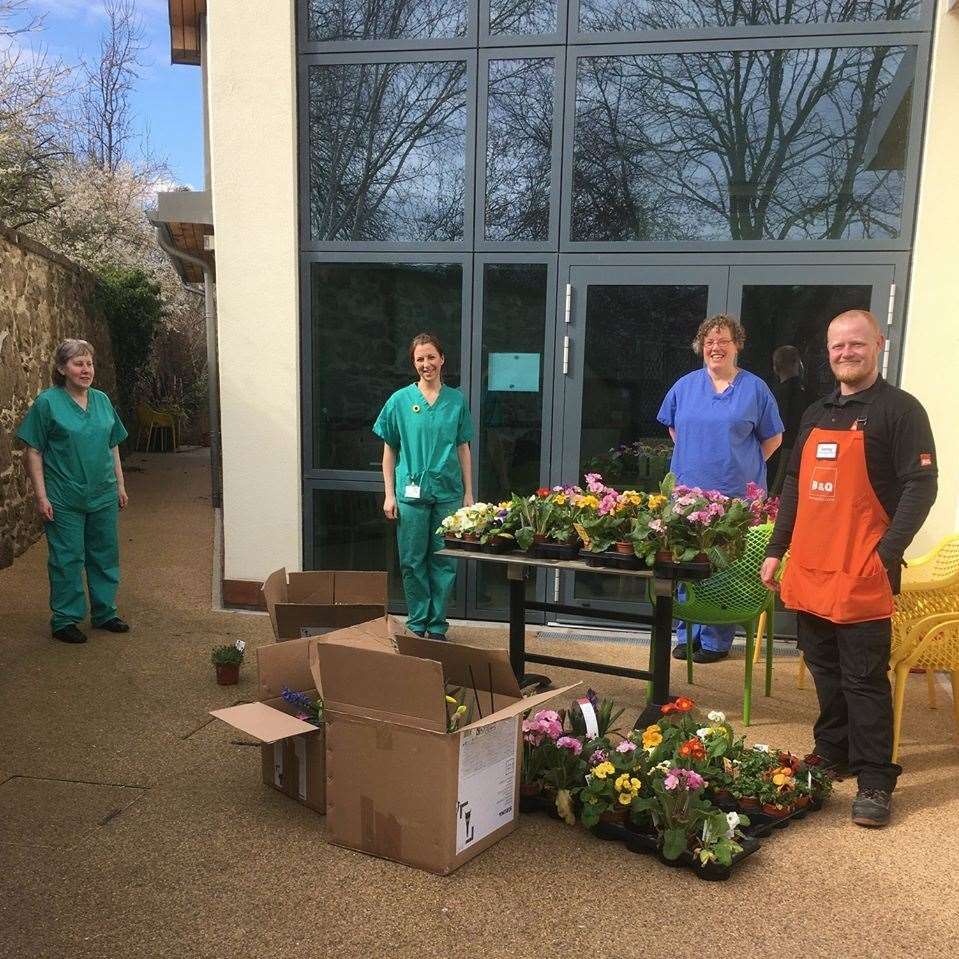 Kenneth Carr of B&Q hands over the flowers to Highland Hospice staff.