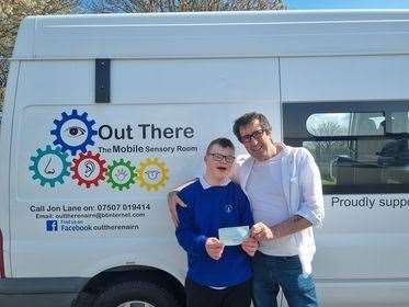 Finlay hands over the cheque to Jon at Nairn Academy.