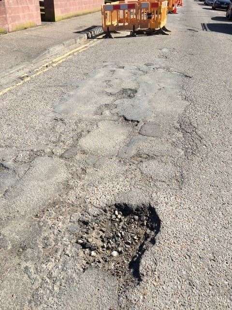 One of the potholes in the street.