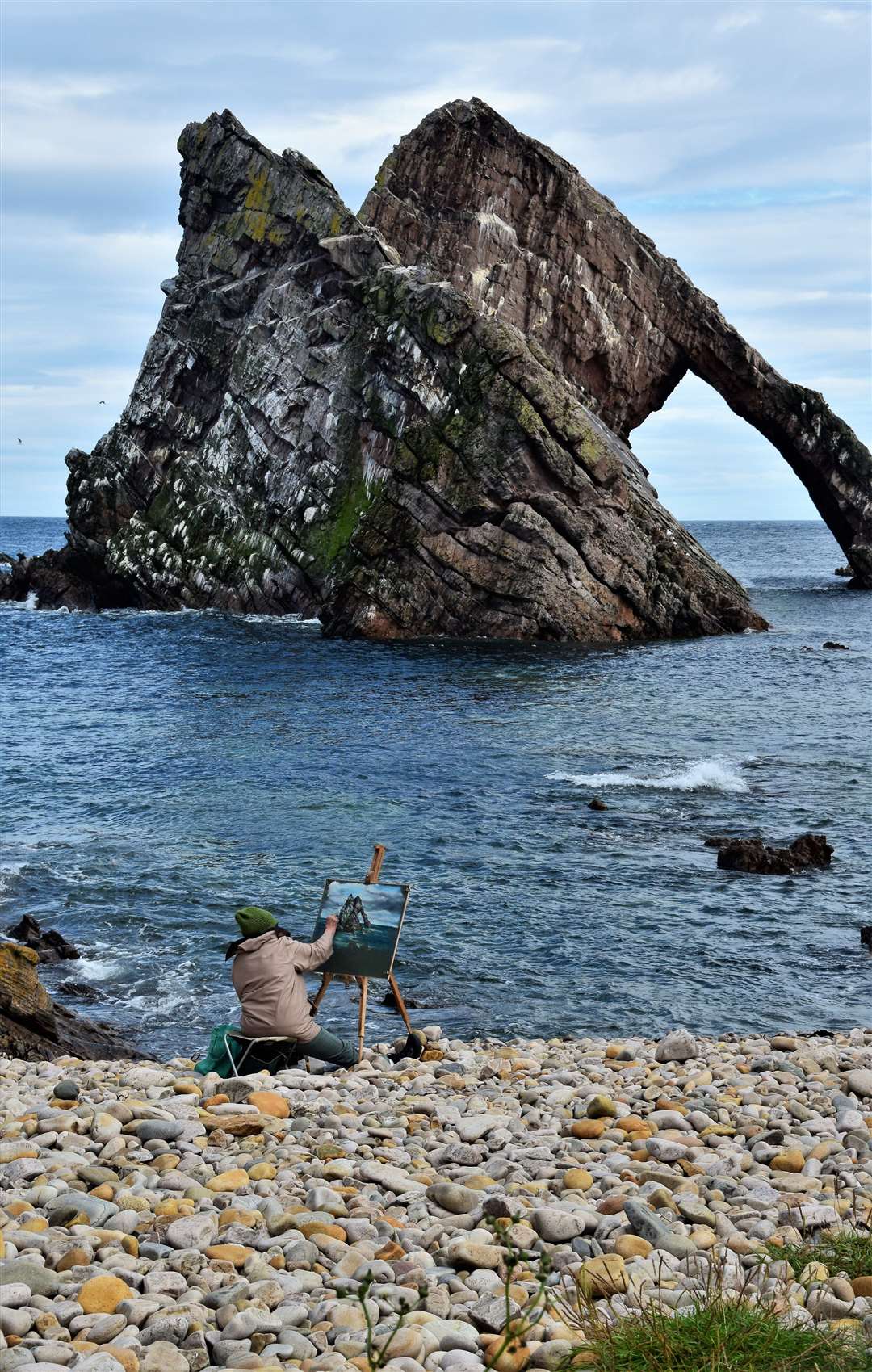 An artist is inspired by the beautiful sea arch of Bow Fiddle Rock at Portknockie. Picture: Philip Murray.