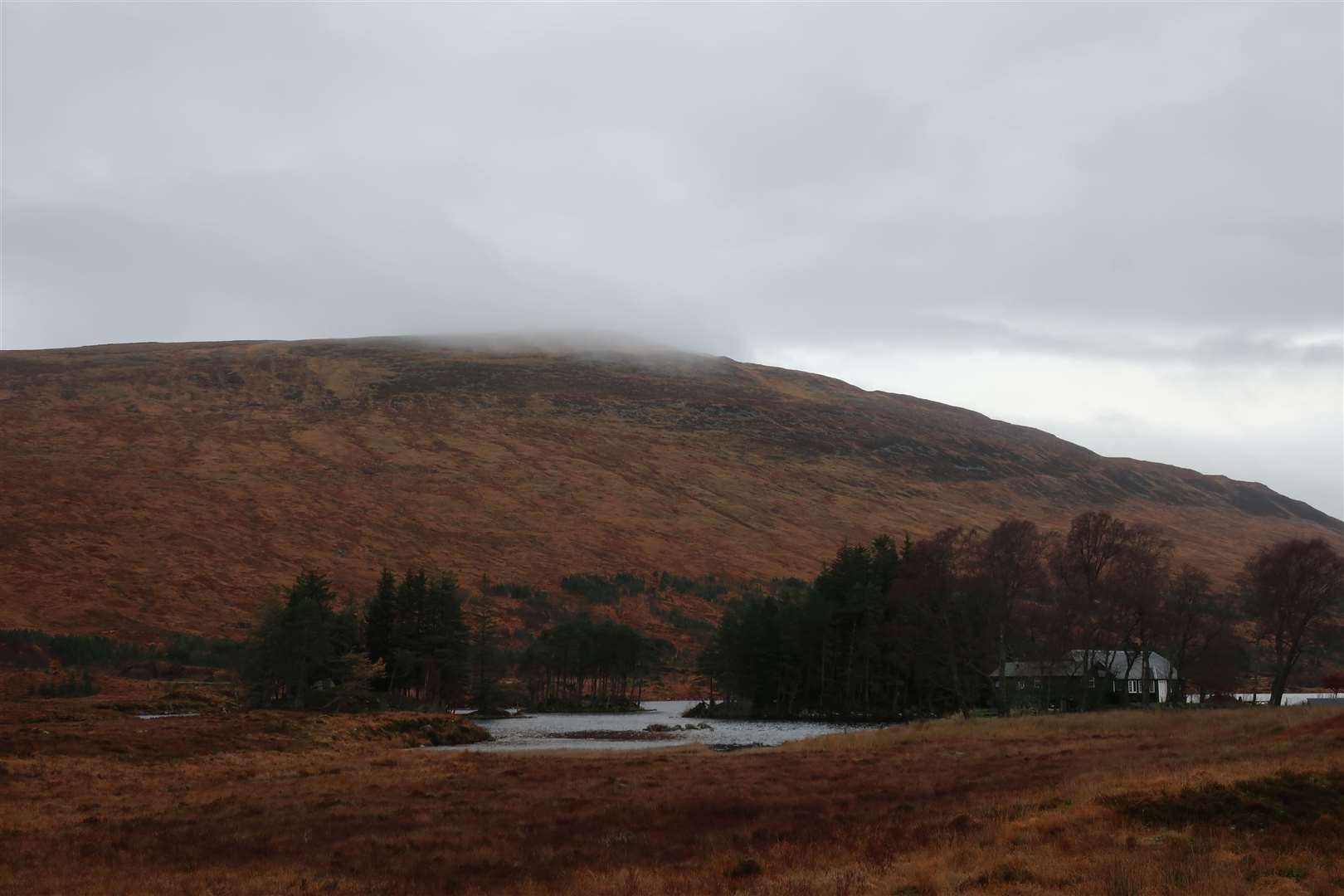 The top of Beinn na Lap in the cloud above Loch Ossian Youth Hostel at the start of the day.