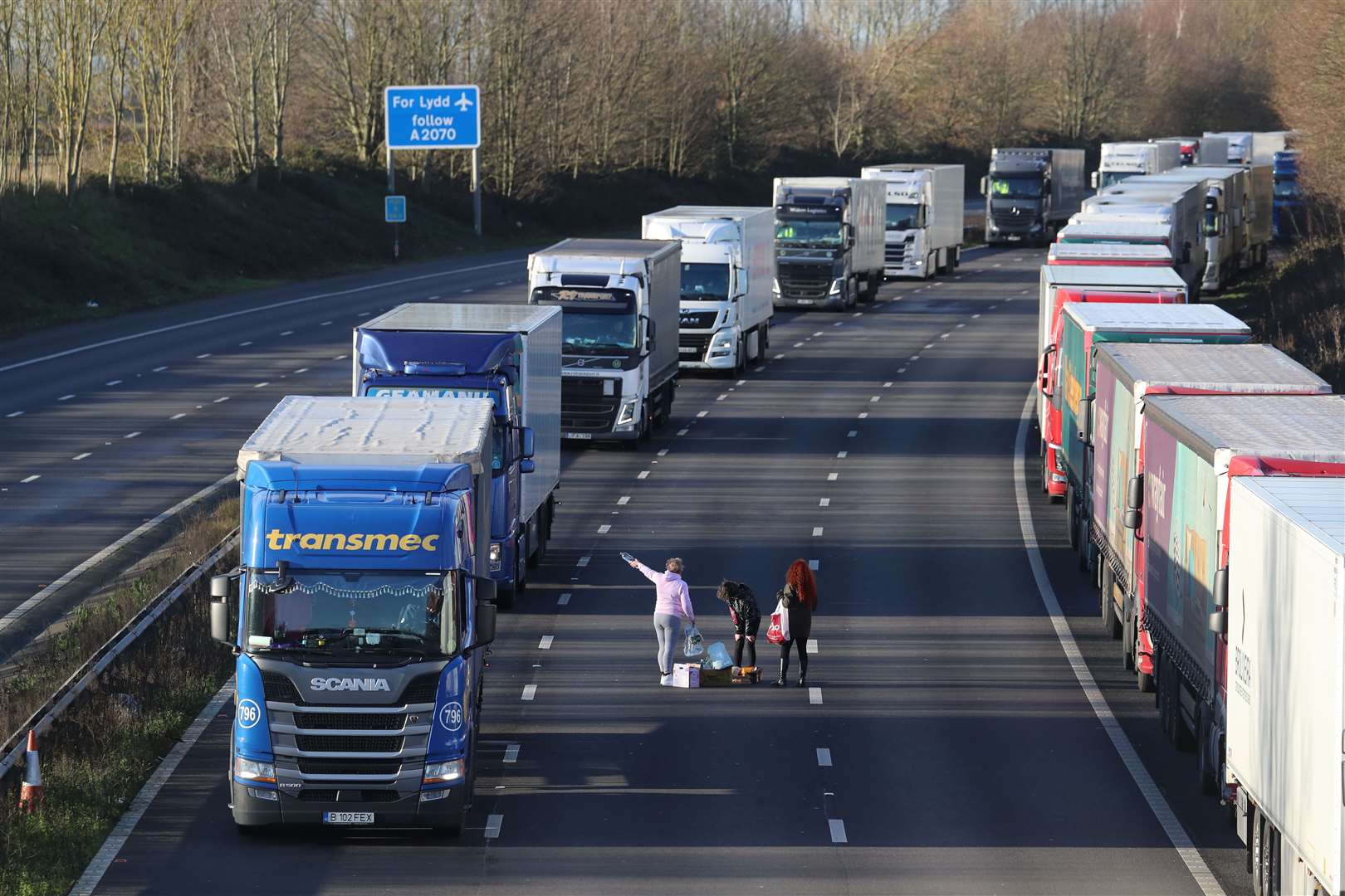 Three women hand out food and water to drivers in their vehicles on the M20 near Ashford, Kent (Gareth Fuller/PA)