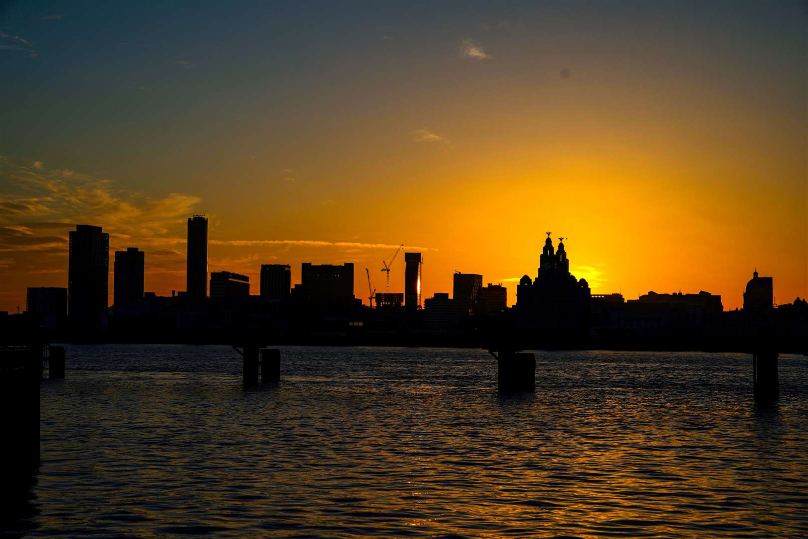 The summer solstice sun rises behind the Liverpool skyline (Peter Byrne/PA)