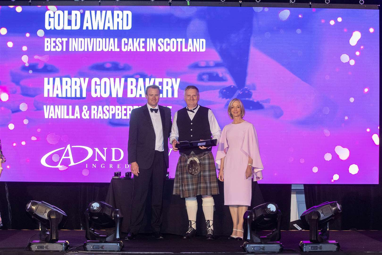 Drew Logie, general manager of Harry Gow (centre) accepts the award for Best Individual Cake, presented by John Graham, managing director of Andrew Ingredients (left) and Scottish Bakers ambassador Mich Turner MBE.