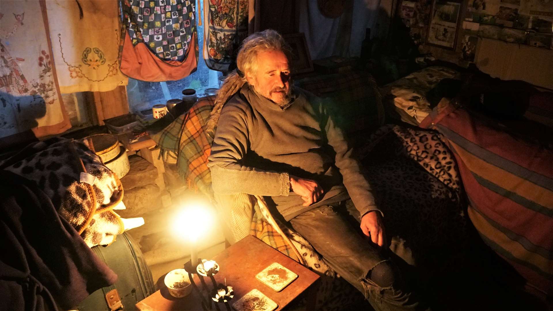 Marcus relaxes in his cosy bedroom. He has no electricity and uses candles to light the house. Picture: DGS
