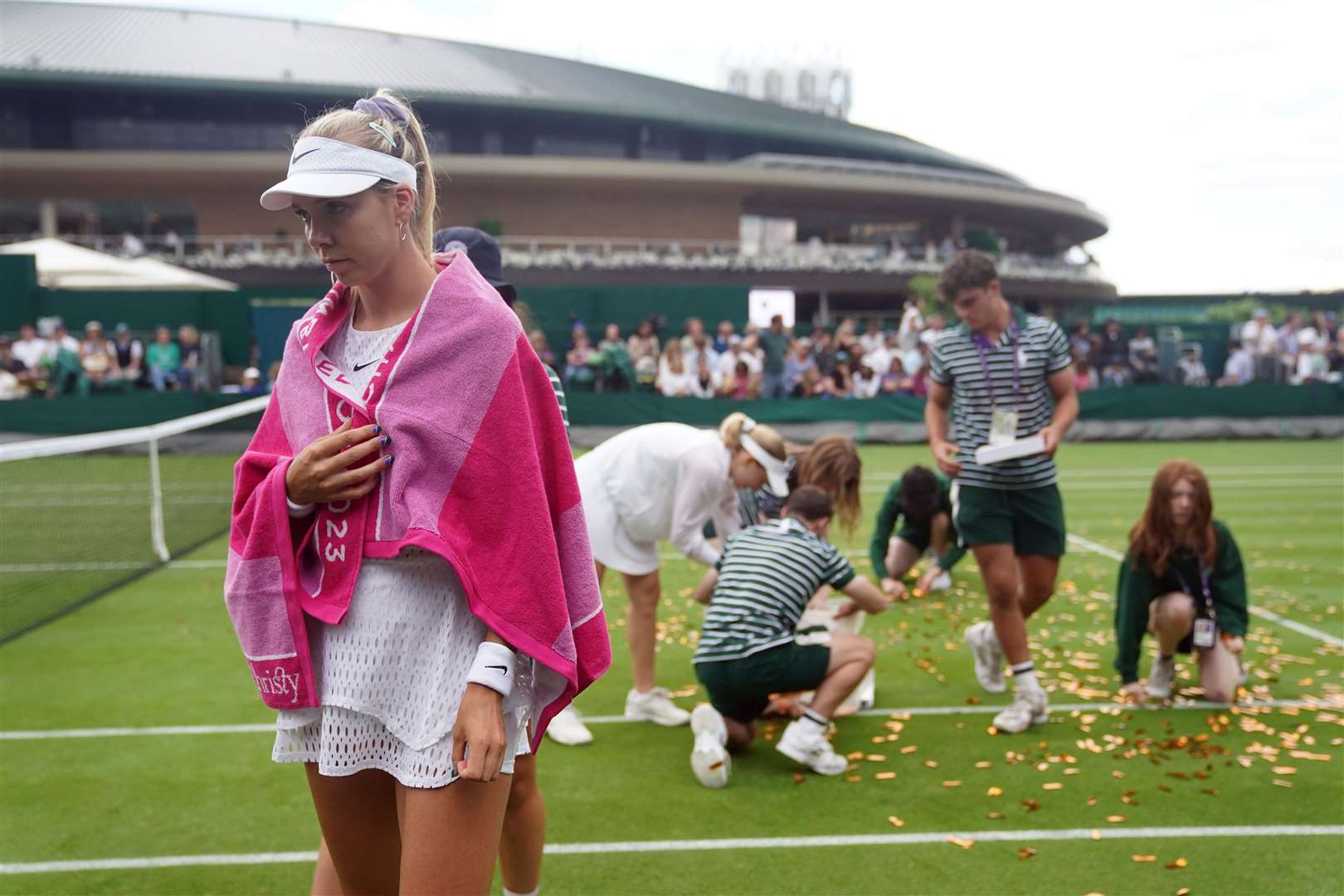Katie Boulter walks away as ground staff clear confetti from Court 18 (Adam Davy/PA)
