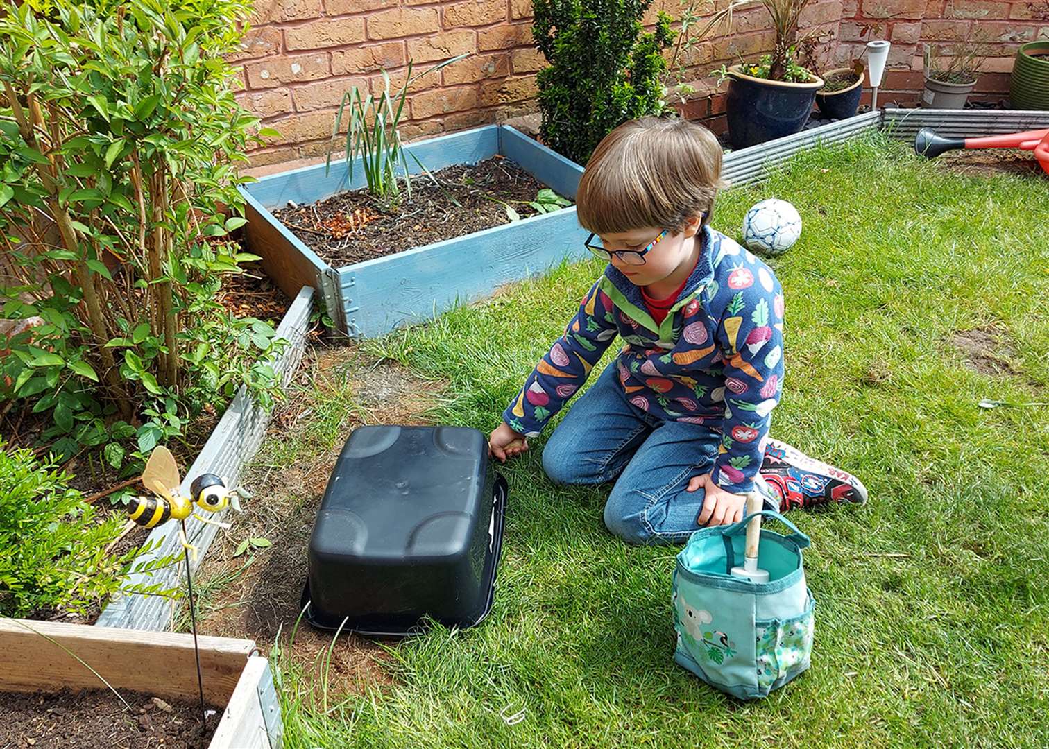Youngster Alastair Hough decides where to dig a hole for the pond. Picture: Garden Organic/PA