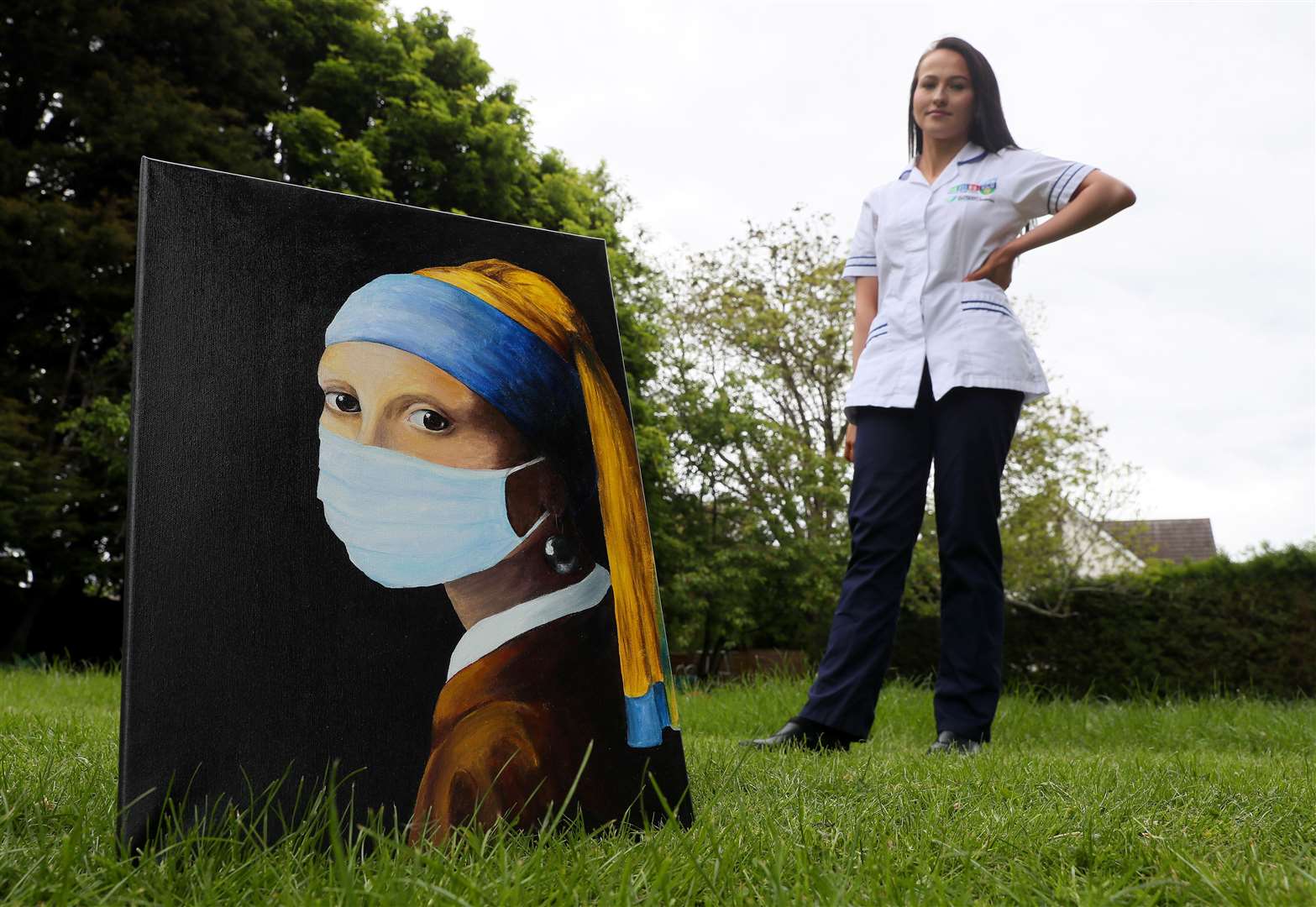 Chloe Slevin with her painting Girl With A Surgical Mask (Brian Lawless/PA)