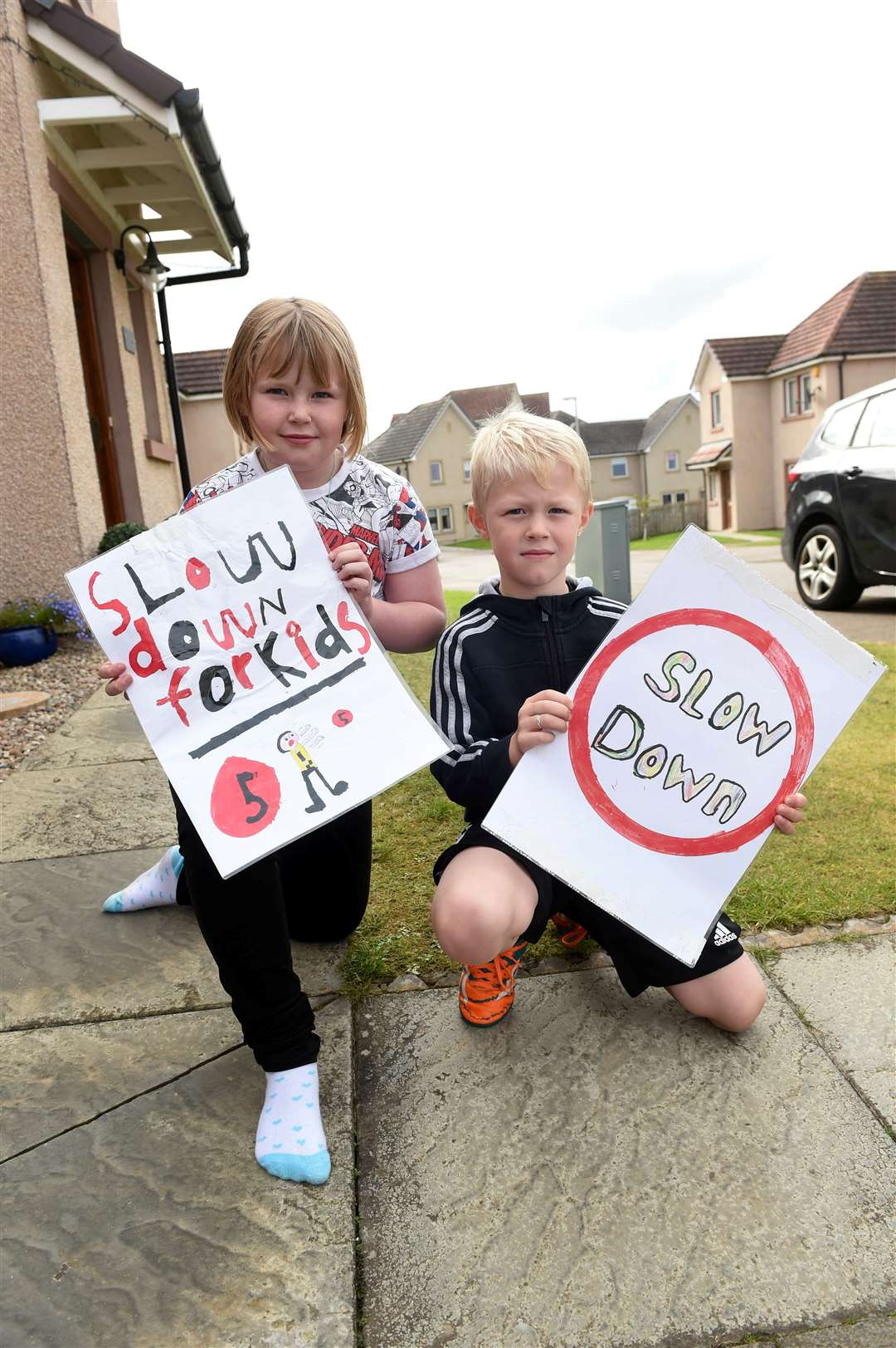 Abbie and Lewis Lindsay with their homemade road signs...Picture: Callum Mackay.