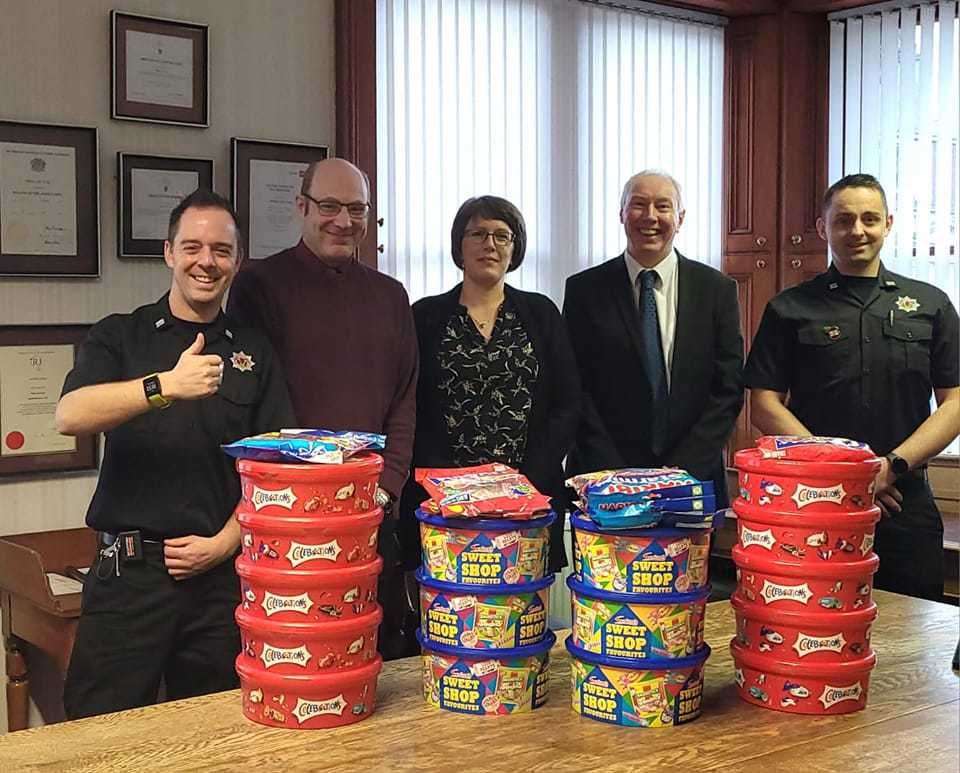 Ritson Young Director Steven Bain and colleagues hand over the sweets to Nairn firemen.