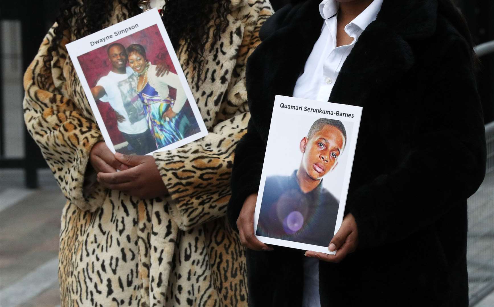 Lorraine Jones, left, and Lillian Serunkuma hold photographs of their sons (Jonathan Brady/PA)