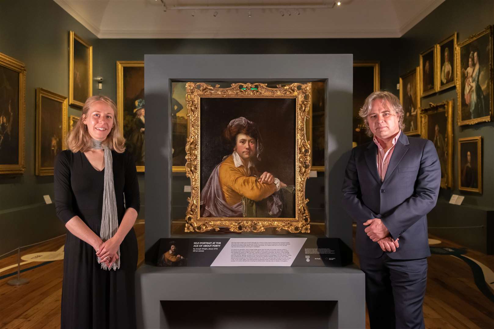 Curator Lucy Bamford and museum director Tony Butler with Self-Portrait at the Age of About Forty by Joseph Wright (Oliver Taylor/PA)