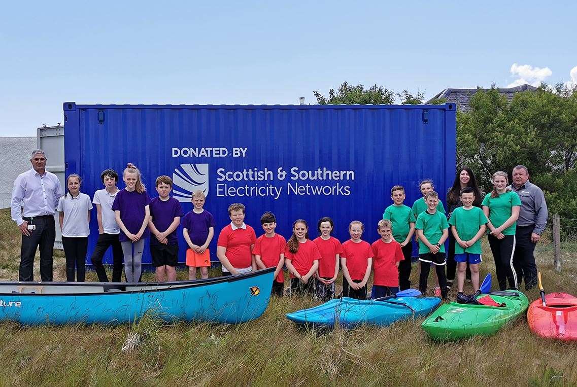 Paul Schofield, Pamela Harvey and CJ MacPhee of SSEN with the donated storage unit which pupils from Daliburgh Primary School will use for storing kayaks and canoes.