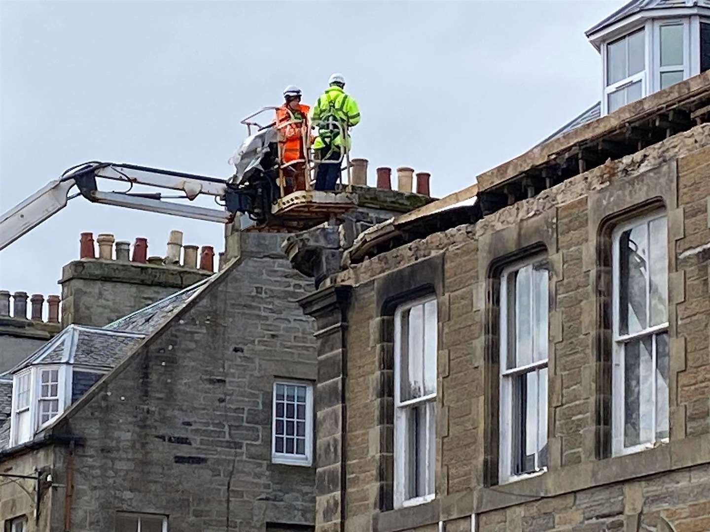 Men working on the damaged parapet this afternoon. Picture: Les Bremner